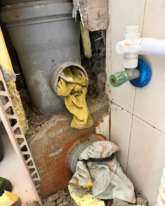 קיר פתוח שבו נראים צינורות ניקוז, והפתחים שלהם סתומים בבדים בזמן העבודה