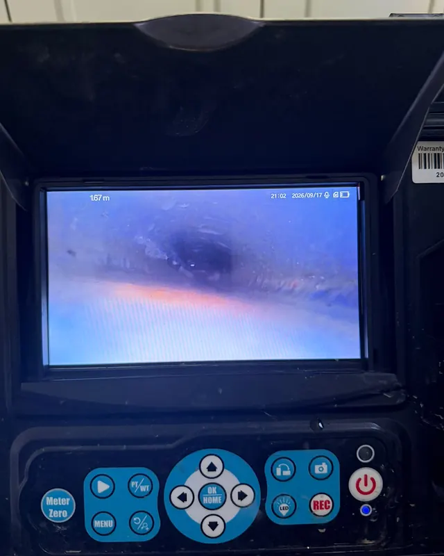 מסך של מצלמת ביוב שמראה את פנים הצינור, ומתחתיו לוח הכפתורים
